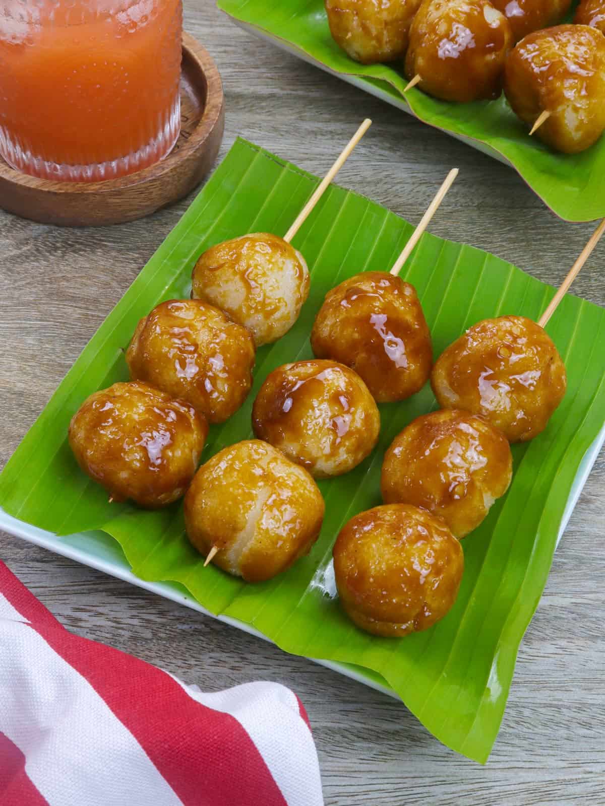 fried sticky rice balls with brown sugar glaze in bamboo skewers.