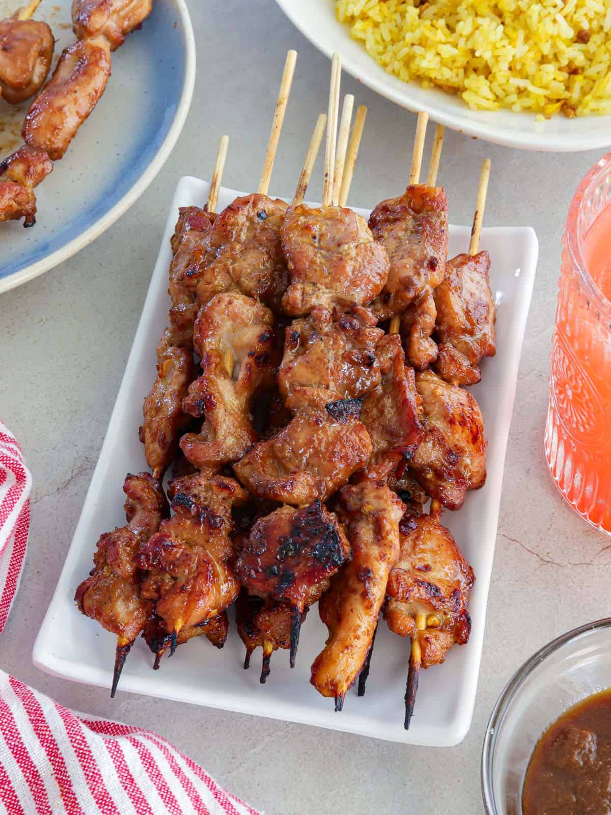 Filipino-style chicken bbq sticks on a white platter.